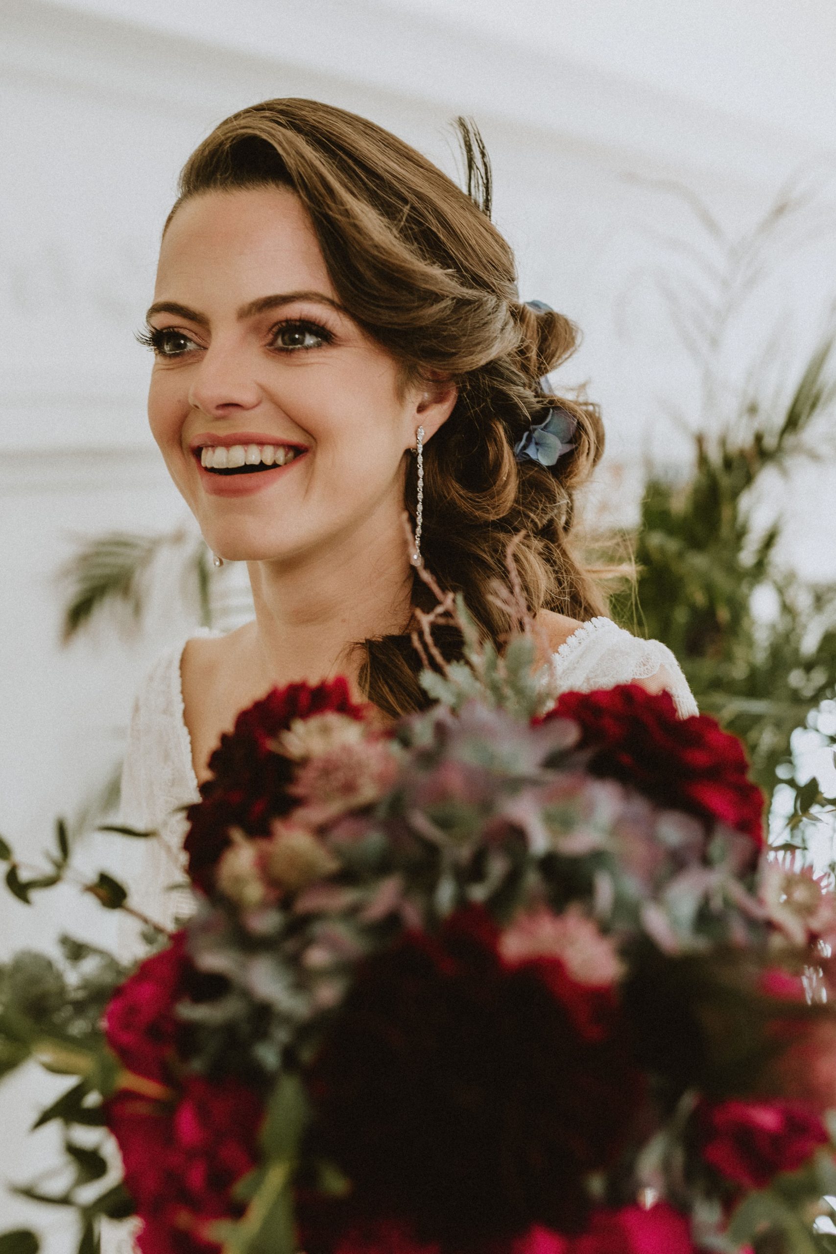 Mariée souriante avec bouquet rouge et vert
