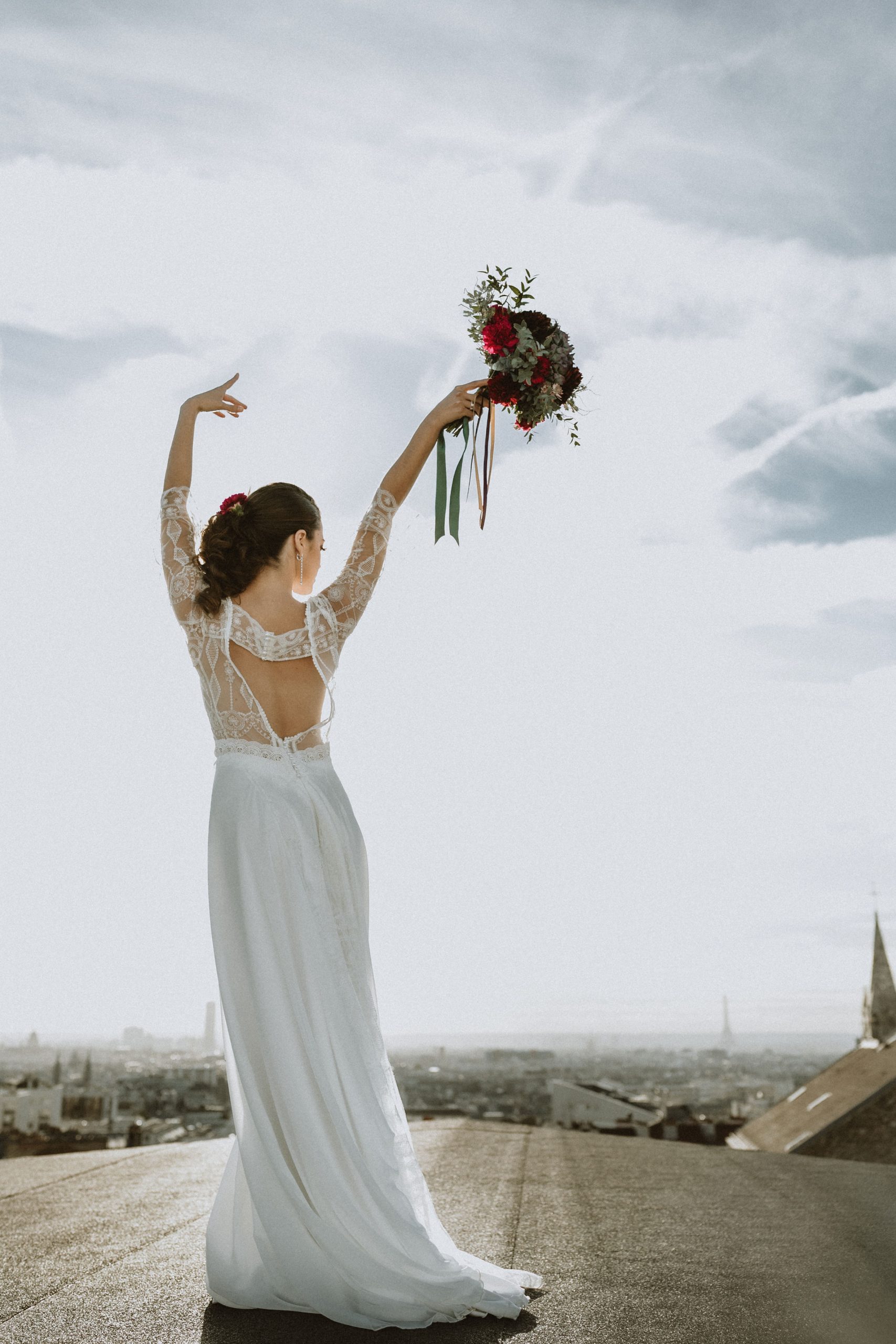 mariée de dos avec bouquet de fleurs à paris